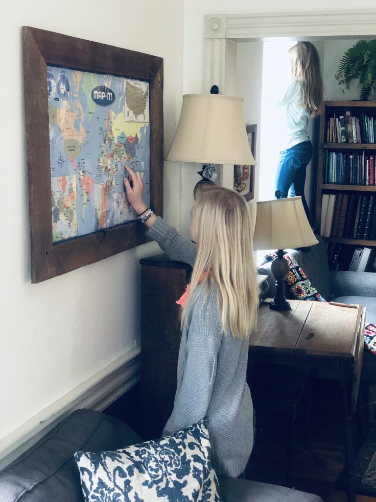 girl looking at a map and another girl looking out the window