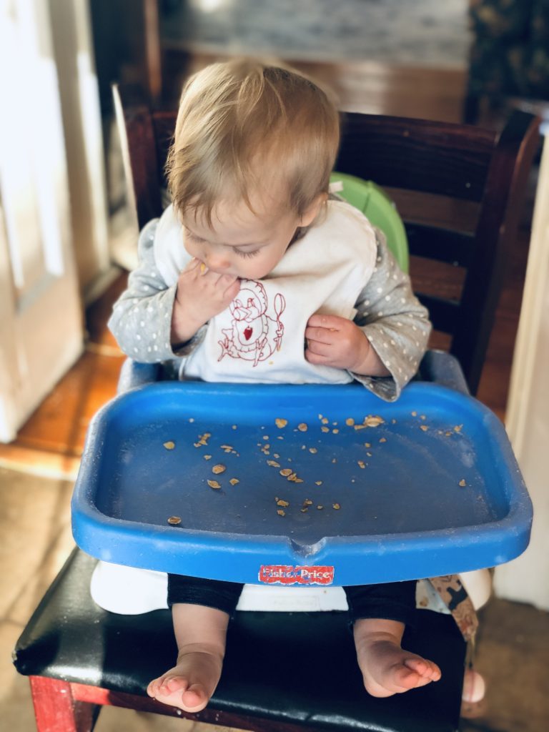 toddler eating in a booster seat